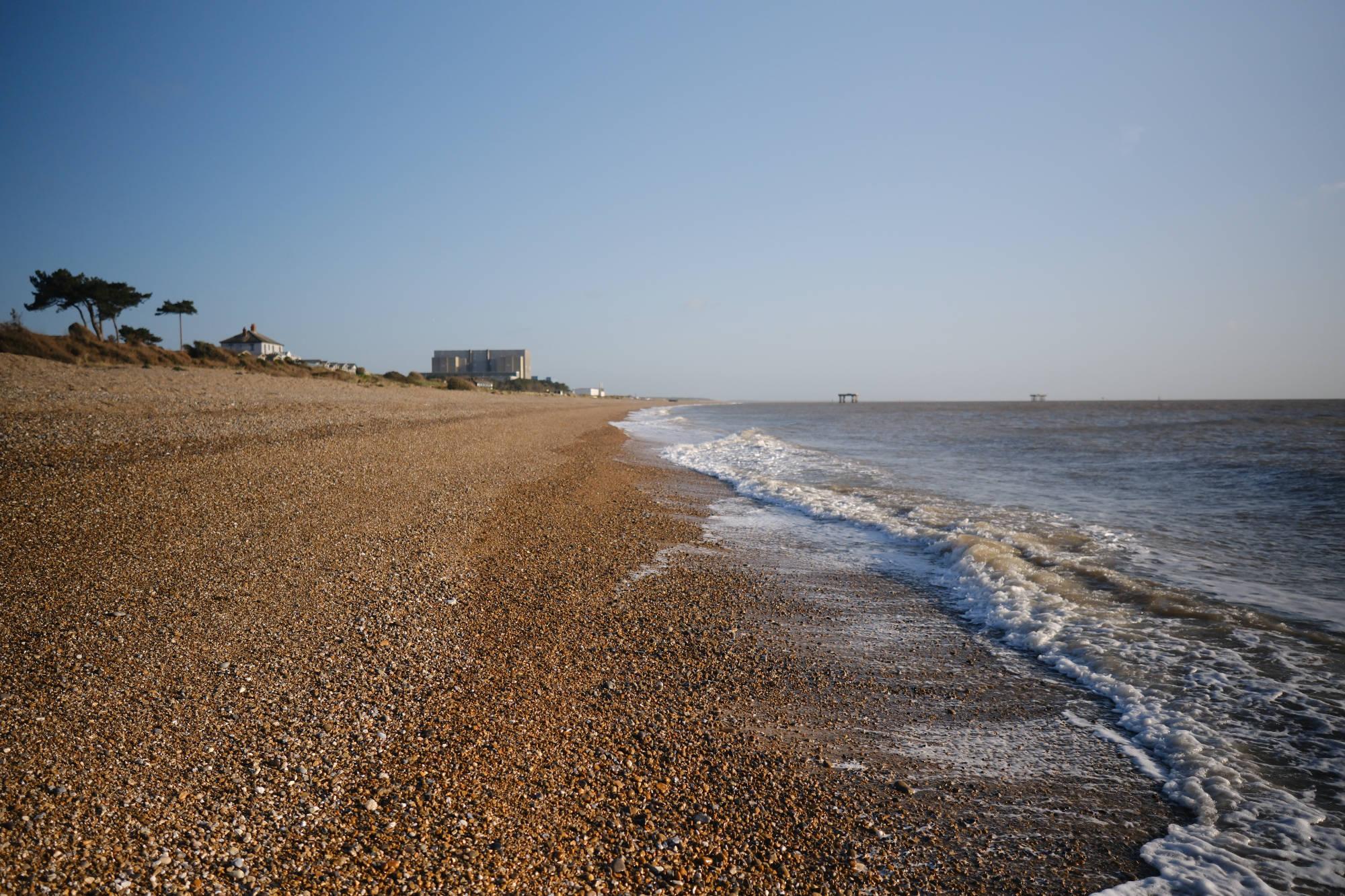 landscape, side view of a beach shoreline, filled pebbles and the tide just coming in... or going out.