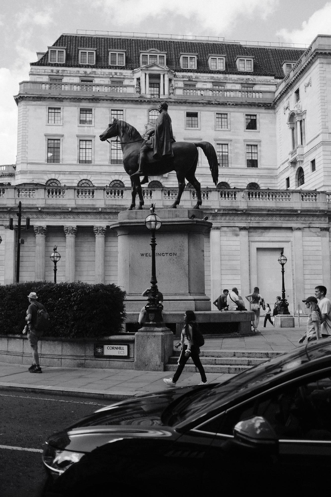 a statue of a man riding a horse in London at Cornhill, grayscale