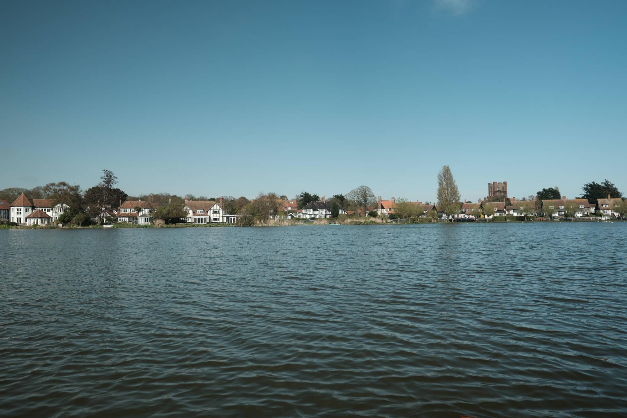 body of water with a small village in the background